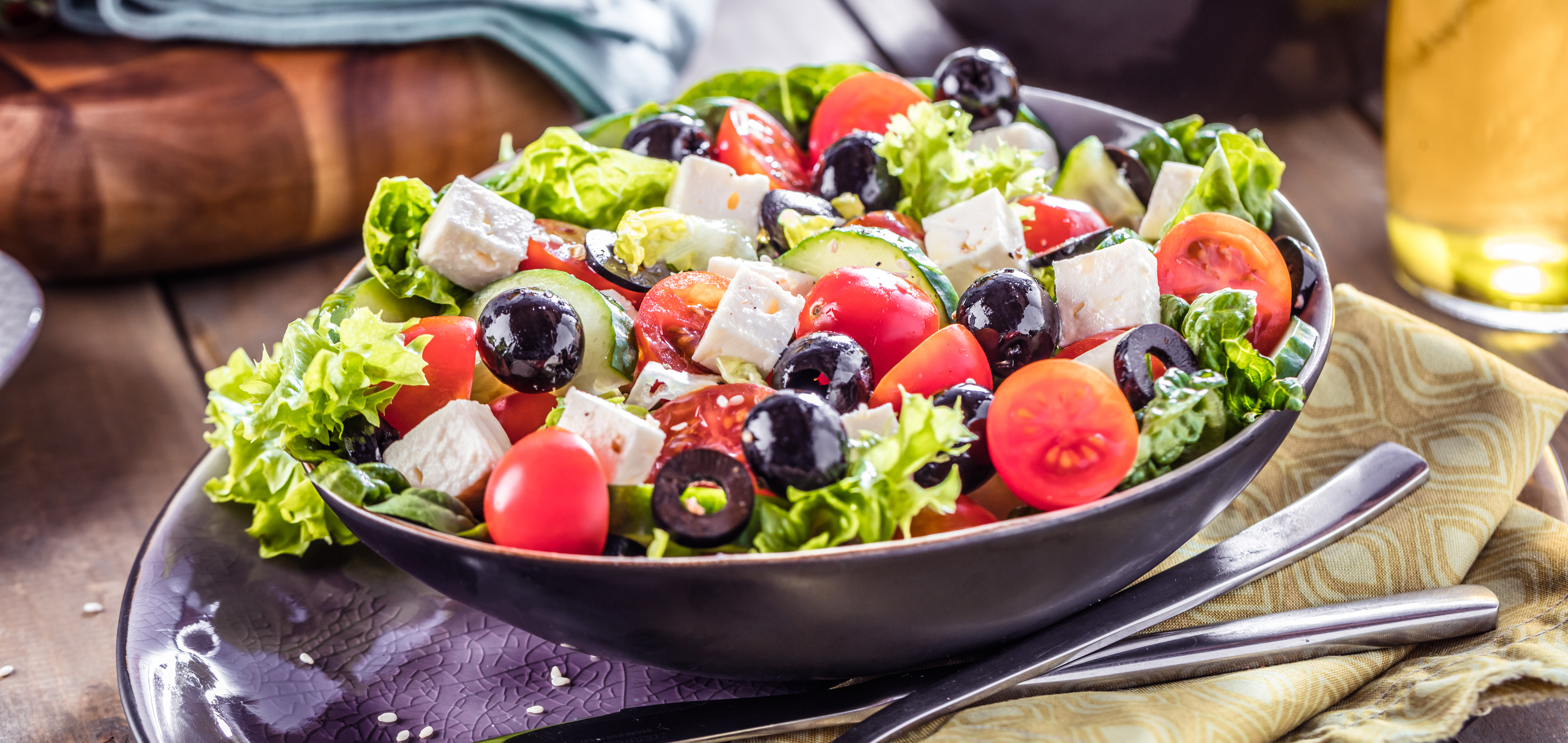 A bowl of salad with tomatoes and olives